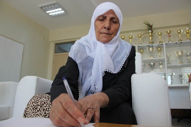 إمرأة ترکیة مسنة تتعلم الکتابة والقراءة في ضوء القرآن