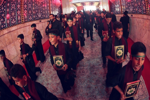 حفظة القرآن الكريم يحملون المصاحف في موكب عزاء