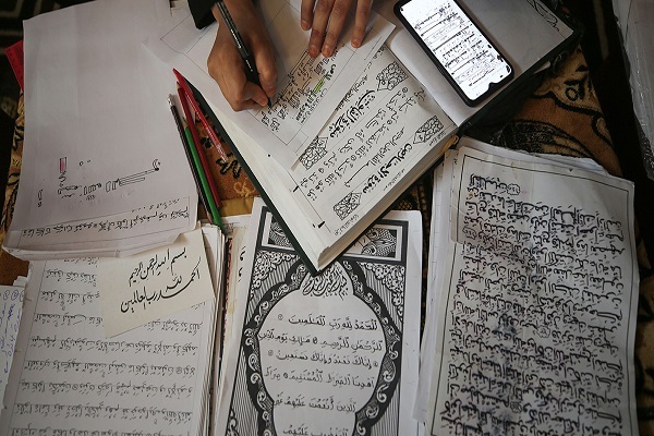 عمل نادر.. أول فلسطينية في غزة تنسخ القرآن بالرسم الكوفي