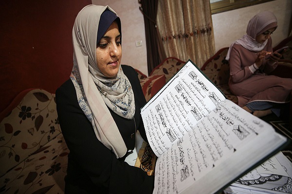 عمل نادر.. أول فلسطينية في غزة تنسخ القرآن بالرسم الكوفي