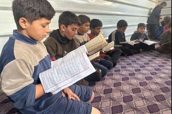 بالصور...نازحون يقيمون مركزاً لتحفيظ القرآن في مركز إيواء بـ