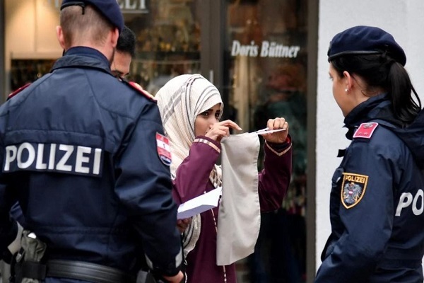 Police officers ask a woman to unveil her face in Zell am See, Austria, on 1 October 2017, following the country's ban on full-face Islamic veils coming into force (AFP)