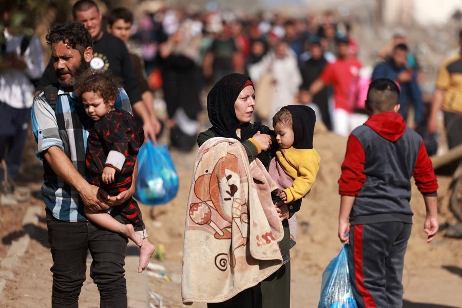 Palestinians fleeing Gaza City and other parts of northern Gaza carry children as the walk along a road leading to the southern areas of the enclave on November 18, 2023, amid Israel's onslaught in the Strip. (Photo by AFP)