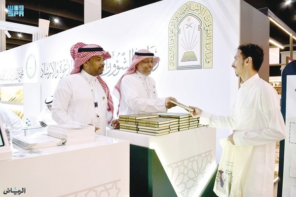 Gifting Qurans to visitors at Medina international book fair