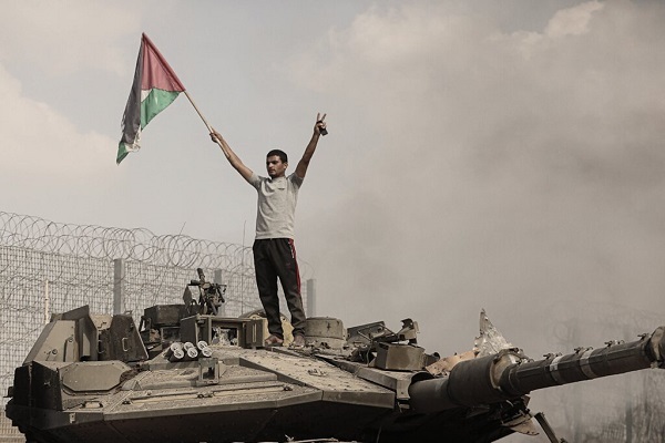A resistance fighter waves the Palestinian flag during the Al-Aqsa Flood Operation