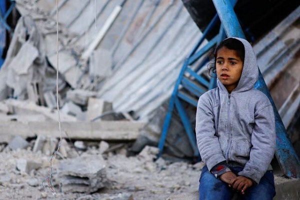 A Palestinian child looking at the destruction in Gaza