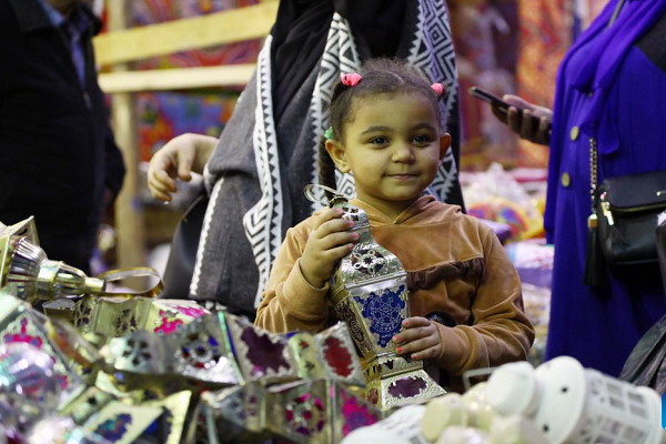 A girl holds a traditional lantern at a market ahead of Ramadan in Cairo, Egypt, on March 6, 2024. (Xinhua)