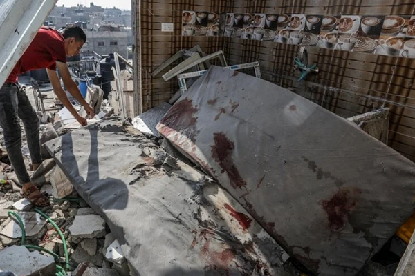 Palestinians gather to inspect the collapsed building following an Israeli strike hit the house belonging to a displaced family in Rafah, Gaza on April 16, 2024