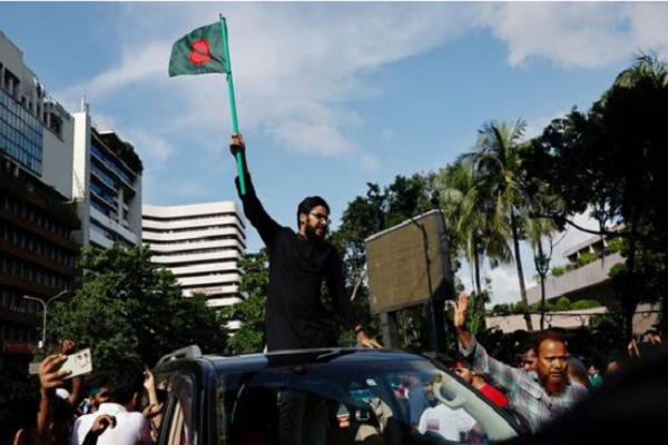 A person waves a flag of Bangladesh, as people celebrate the resignation of Prime Minister Sheikh Hasina in Dhaka, Bangladesh, August 5, 2024