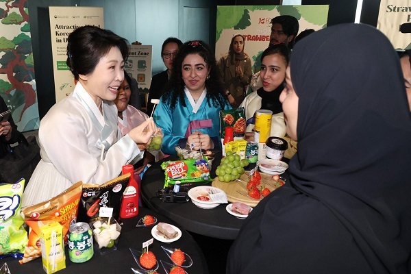 South Korean First lady Kim Hea Kyung tries a snack during a promotional event for halal-certified Korean food at the Korean Cultural Center in Abu Dhabi, the United Arab Emirates. (November 19, 2025)