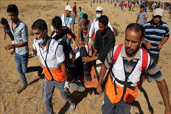 Medical staff carrying a wounded Gazan to a medical center during the Israeli war on Gaza