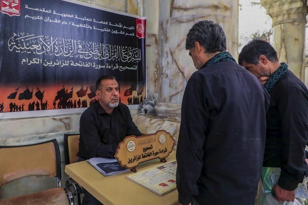 A Quran teacher helps correct pilgrims’ recitation of short Surahs of the Quran during the 2025 Arbaeen procession in Iraq.