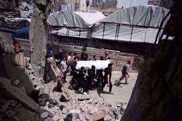 Palestinian mourners carry the body of one killed in Israeli strikes on the Gaza Strip on May 17, 2026.
