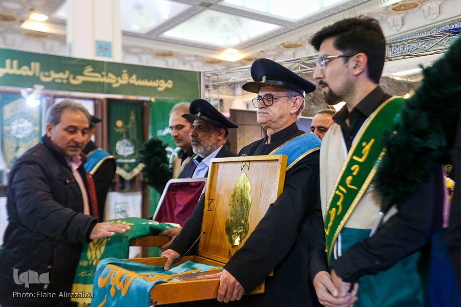پرچم‌گردانی خادمان حرم امام رضا(ع) در نمایشگاه قرآن