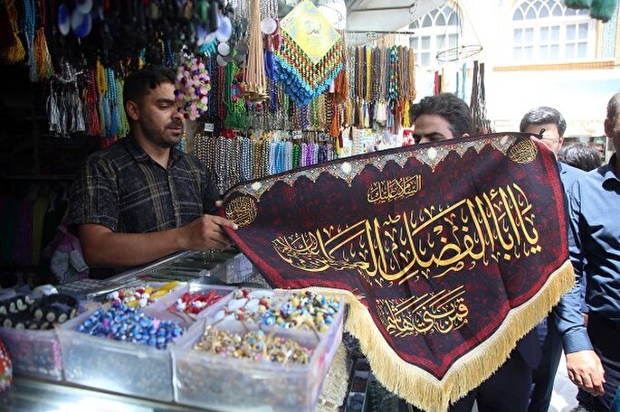 عکس | اهدای پرچم عزای سیدالشهدا(ع) به کسبه اطراف حرم بانوی کرامت