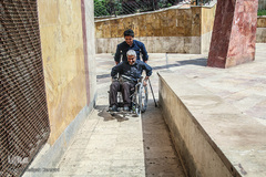 کمک کردن به یکی از معلولان برای سوار شدن به سرویس 