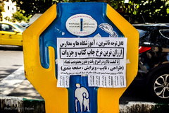 چسباندن پوسترهای تبلیغاتی بر روی صندوق صدقه