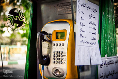 چسباندن پوسترهای تبلیغاتی بر روی کیوسک تلفن عمومی