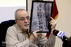 استاد حبیب مهکام، پیشکسوت قرآنی در حال نمایش عکس یادگاری استاد «محسن مظاهری» با پدر و برادران خود