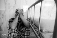 محمدحسن بعد از اتمام ملاقات با مادر خود به حالت دلتنگی در کنار تخت نشسته است.