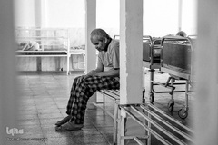 محمد حسن تنها در بخش خود به روی نیمکت نشسته است.