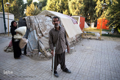 پیرمردی معلول و ناتوان که به علت ازکارآفتادگی و عدم توانایی پرداخت اقساط وام بازسازی مسکن آسیب دیده خود، ناگزیر با خانواده در چادری مستقر در یک پارک زندگی می کند