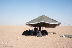 در چادری در بیابان، آوارگان منتظر تایید هویت خود توسط نیروهای دمکرات سوریه هستند تا اجازه ورود به کمپ موقت آوارگان داخلی را بیابند.
