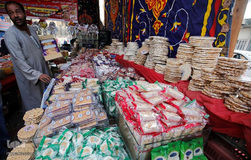 یک فروشنده دوره‌گرد که در بازار قاهره برای جشن میلاد پیامبر شیرینی می‌فروشد منتظر مشتری است.