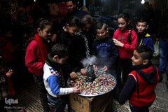 در جشن میلاد پیامبر در نابلس فلسطین، بین کودکان شیرینی و شکلات پخش می‌کنند.