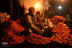 یک فروشنده دوره‌گرد به مردم شرکت کننده در جشن میلاد پیامبر در مقدس‌ترین مقبره کشمیر یعنی مقبره حضرت‌بال در سرینگر خوراکی‌های سنتی می‌فروشد.