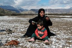 زن روستایی منتظر است تا با تراکتور فرزندش را به درمانگاه ببرد، اغلب زنان برای رفت و آمد از روستای خود به مناطق دیگر از این رودخانه عبور می‌کنند.
