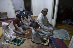 نماز جماعت پدر خانواده مهاجر سوری و فرزندانش در شهر آتن، یونان

