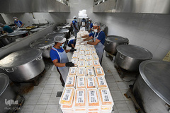 داوطلبان در حال بسته‌بندی غذا برای کارگران مهاجر در شهر دبی، امارات متحده عربی


