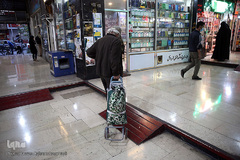 یک پیرمرد خریدار کتاب در بازار کتاب میدان انقلاب