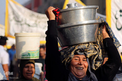 زنان مصری گلدان های پر از غذا را حمل می کنند تا به طور رایگان در میان روزه داران در محله الحسین در مرکز قاهره توزیع کنند