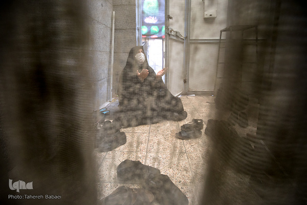 یکی از خانم ها به دلیل محدودیت فضا و رعایت فاصله اجتماعی در حیاط نشسته است.