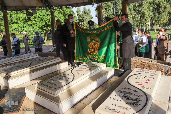 خدام حرم مطهر رضوی بر مزار شهدای گمنام در پارک جزیره اهواز