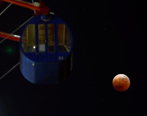 نمایی از ماه‌گرفتگی در زمینه چرخ و فلکی در پارک توکیو ژاپن