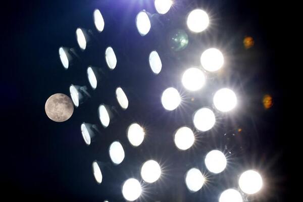 نمای کلی ماه در کنار نورافکن ورزشگاهی در  آلبانی.