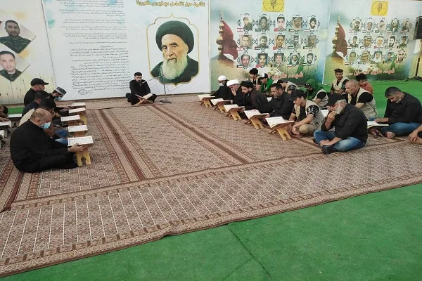 بالصور والفيديو...موكب كتائب حزب الله يقيم محفلاً قرآنياً على طريق 