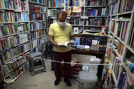 رعایت پروتکل های بهداشتی و فاصله گذاری اجتماعی توسط فروشندگان کتاب در بازار کتاب میدان انقلاب