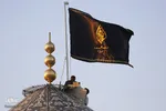 اهتزاز پرچم عزا بر فراز گنبد فيروزه‌اي آستان شاهچراغ(ع)
