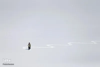 یک مرد افغان برای فروش تخم مرغ های آب پز شده خود در بازار، از دریاچه پوشیده از برفی در شهر کابل افغانستان عبور می کند.