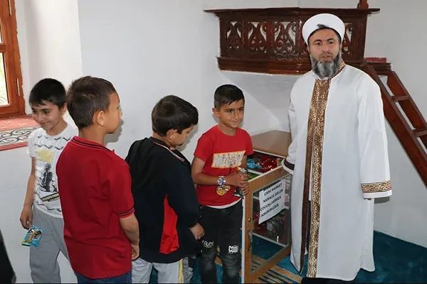 Köy imamı camiye gelen çocuklara ikramda bulunup birlikte oyun oynuyor