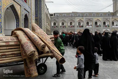 جمع آوری قالی ها در زمان بارش باران یکی از جذابترین لحظات برای کودکان حاضر در حرم امام رضا (ع) است. 