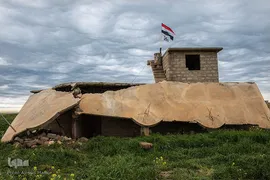 خانه ای در کوجو که در پشت بام آن پرچم عراق مشاهده می‌شود، در طی اشغال داعش این خانه تخریب شد.