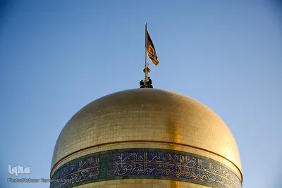 اهتزاز پرچم عزای حسینی بر فراز گنبد حرم رضوی
