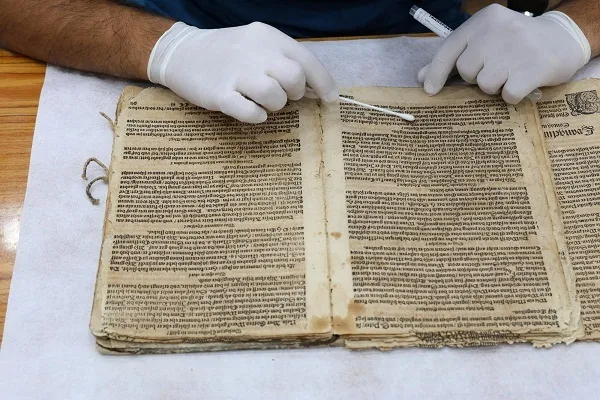 Début de la restauration d'une ancienne version de l'Évangile en allemand à l'Astan Qods Abbasie + photos 