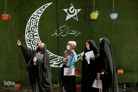 زنان عراقی در حال سلفی گرفتن با نقش هلال ماه رمضان روی دیوارهای شهر نجف 
