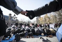 Lingkar Kemanusiaan Sekitar Jamaah Salat dalam Demo Anti Trump oleh Non Muslim
